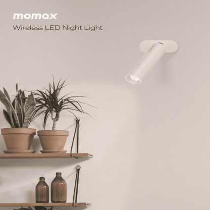 Wireless LED night light by momax on a wall with plants and shelves in the background