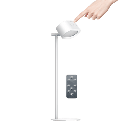 White adjustable desk lamp with remote control on a green background