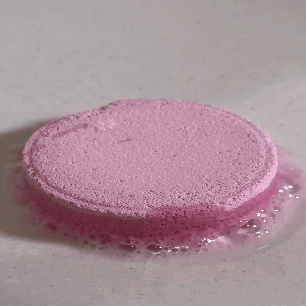 Pink sponge with foam on a white surface