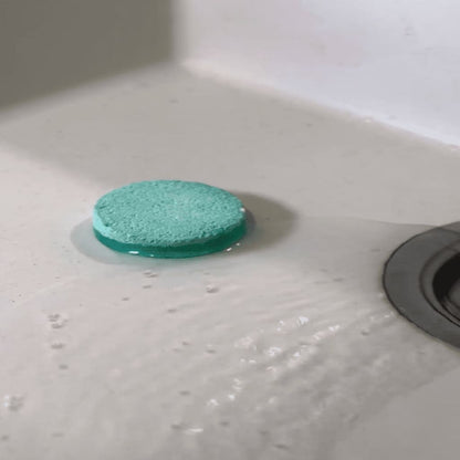 Green sponge on a white sink