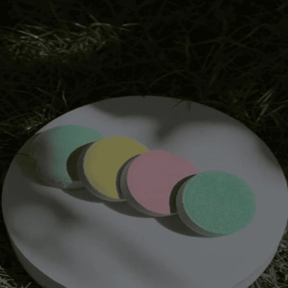 Colorful circular objects on a white plate with grass in the background