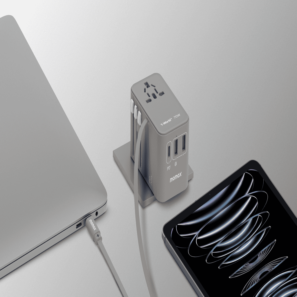 Power adapter with multiple ports next to a laptop and tablet on a light gray background