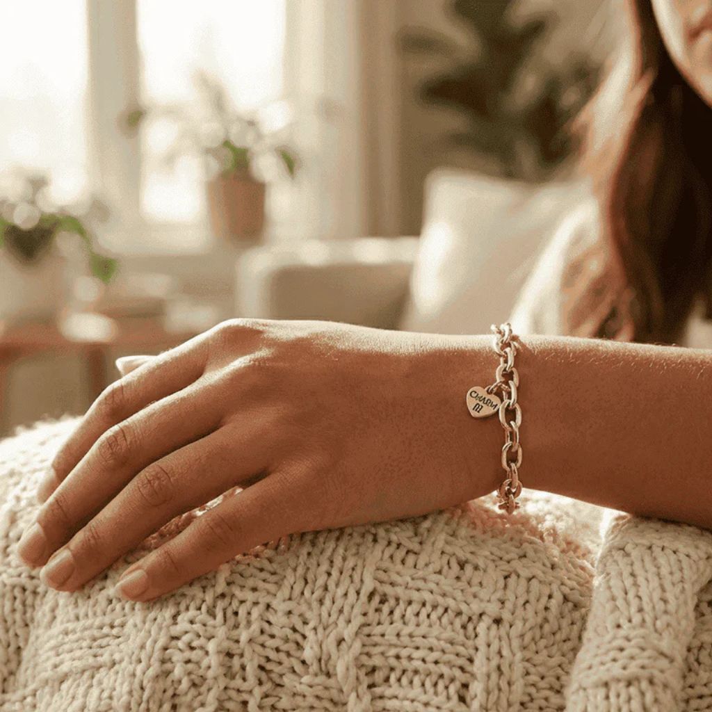 Person wearing a bracelet with a heart charm on a textured surface indoors