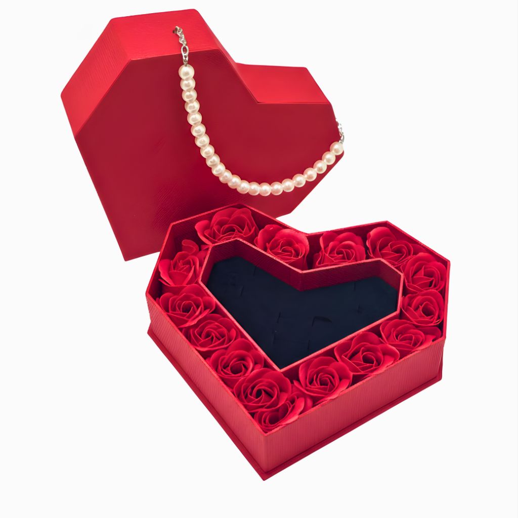 Red heart-shaped box with red roses and a pearl necklace on a white background