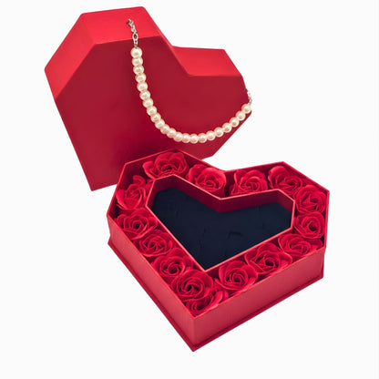 Red heart-shaped box with red roses and a pearl necklace on a white background