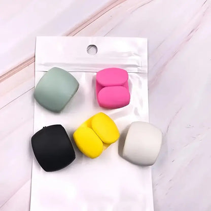 Set of colorful square-shaped objects on a white card with a pink background