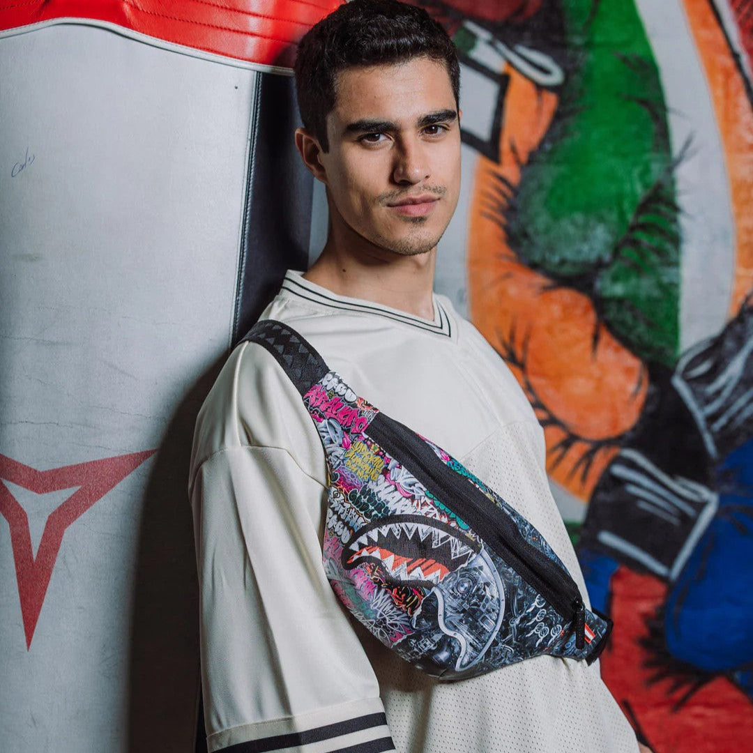Man wearing a colorful fanny pack with a graffiti wall background