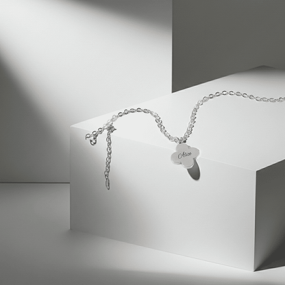 Silver bracelet with a heart-shaped tag on a white and gray geometric background
