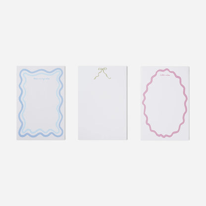 Three white cards with decorative borders on a light gray background